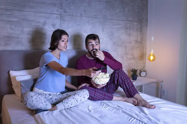 Güzel, birbirine aşık genç bir çift yan yana oturmuş, patlamış mısır yiyor ve geceleri korku filmi izlerken eğleniyorlar.