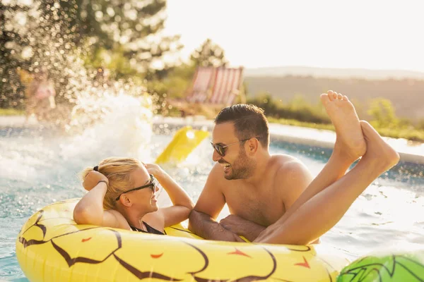 Havuz başında bir yaz partisinde aşık bir çift, güneşleniyor ve eğleniyor; kız ananas şeklinde bir şişme yatakta havuzda yüzüyor. 