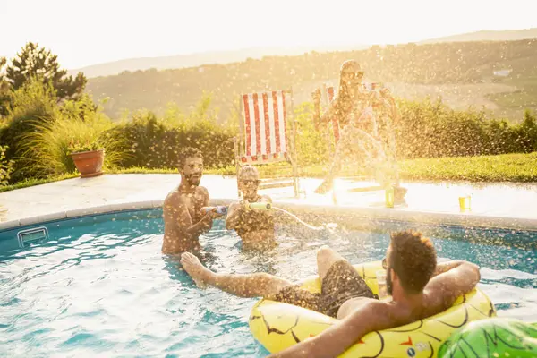Havuz başında bir yaz partisinde bir grup arkadaş yüzme havuzunda eğleniyor, bira içiyor ve su sıçratıyor.