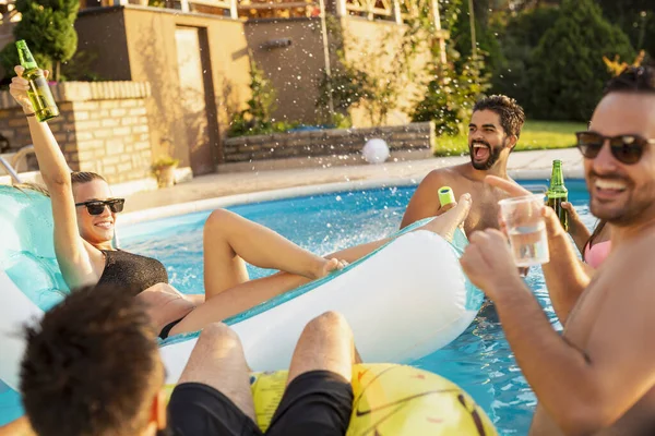 Havuz başında bir yaz partisinde bir grup arkadaş, yüzme havuzunda eğleniyorlar, kokteyl ve bira içiyorlar ve kadeh kaldırıyorlar.