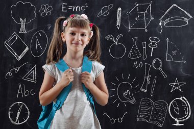 Sırt çantası takan liseli kız, okulun ilk gününde bir tahtanın önünde duruyor.