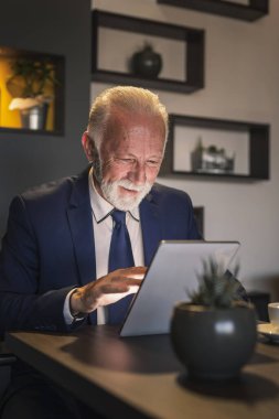 Bir restoranda çalışan kıdemli işadamı, bir tablet bilgisayarda iş ve finans haberleri okuyor.