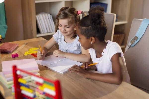 Две Маленькие Девочки Сидят Столом Пишут Блокнотах Делают Домашнее Задание — стоковое фото