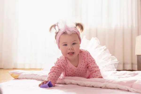 漂亮的小女孩穿着粉红短裙 爬在地板上 第一次独立行动 — 图库照片