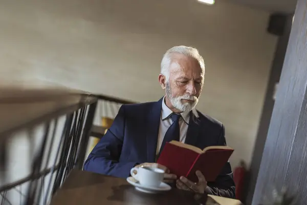 Starší Podnikatel Sedí Stolu Restauraci Čte Knihu Pije Kávu — Stock fotografie