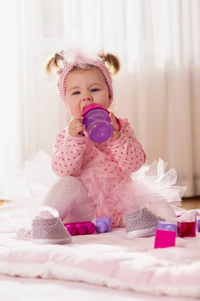 Mooi Klein Meisje Met Roze Tutu Rokje Zittend Babyvloer Drinkwater — Stockfoto