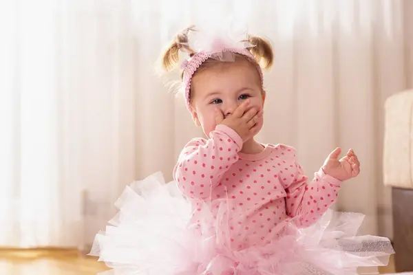 漂亮的小女孩坐在育婴室的地板上 用手吻着 — 图库照片