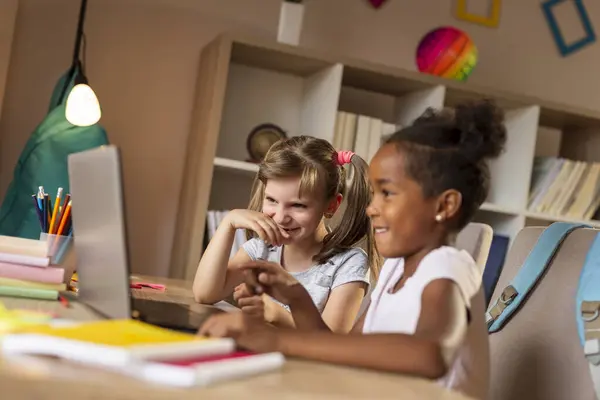 Две Красивые Маленькие Девочки Сидят Столом Смотрят Мультики Ноутбуке Веселятся — стоковое фото
