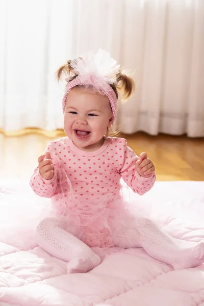 リビングルームの床に羽毛布団の上に座っている美しい小さな赤ん坊の少女 笑顔と拍手 — ストック写真