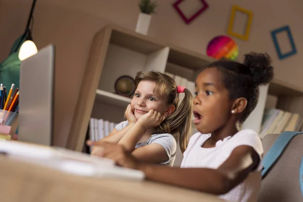 Две Красивые Маленькие Девочки Сидят Столом Смотрят Мультики Ноутбуке Веселятся — стоковое фото