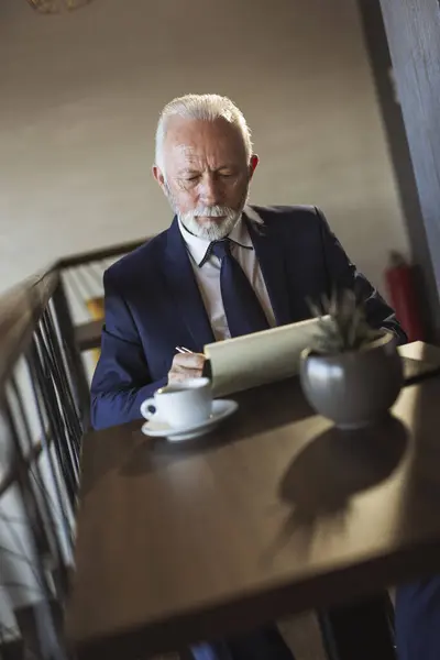 Senior Businessman Sedí Moderní Kancelářské Budově Restaurace Pije Kávu Podepisuje — Stock fotografie