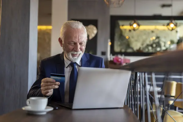 Senior Zakenman Zit Aan Een Restauranttafel Koopt Internet Betaalt Met — Stockfoto