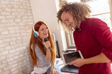 İş adamları ofiste karaoke yapıyor, şarkı söylüyor, dans ediyor ve ara verirken eğleniyorlar.