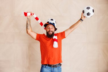 Erkek futbol taraftarının portresi elinde tezahürat eşarbı ile takımının gol atmasını ve maçı kazanmasını kutluyor.