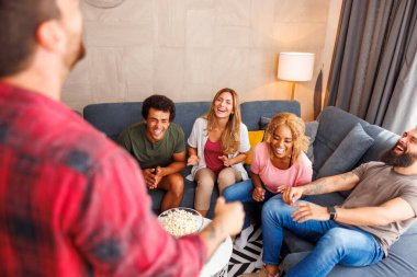 Bir grup arkadaş evde birlikte vakit geçirirken pandomim yaparken eğleniyorlar.