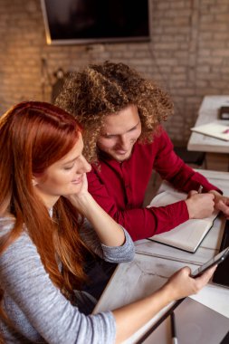 Yazılım geliştirme şirketinde yeni bir proje üzerinde çalışan iki yazılım geliştiricisi; modern ofiste birlikte çalışan iş adamları