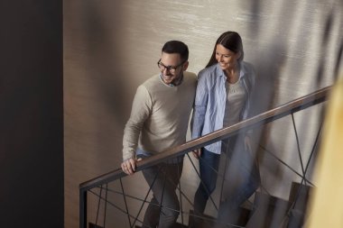 Aşık çift restoranda buluşuyor, sarılıyor, kameraya bakmıyor ve merdivenlerden yukarı çıkıyor.