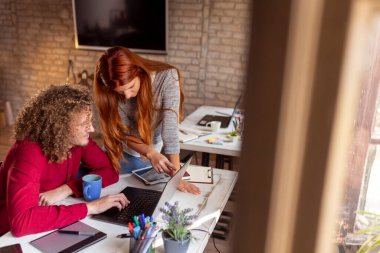 Ortak çalışma alanında çalışan serbest programcılar; modern ofiste çalışan genç iş adamları