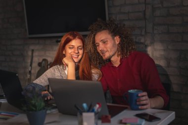 Ortak çalışma alanında çalışan serbest programcılar; modern ofiste çalışan genç iş adamları