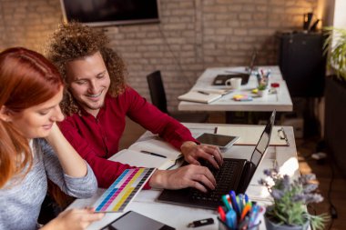 Modern çalışma alanında yeni bir proje üzerinde çalışan tasarımcılar; modern ofiste çalışan genç iş adamları