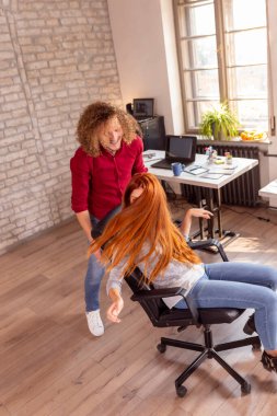 İş arkadaşları ofiste bir sandalye yarışını organize ederken eğleniyorlar; serbest çalışanlar iş yerinde eğleniyorlar, sandalyelerle yarışıyorlar