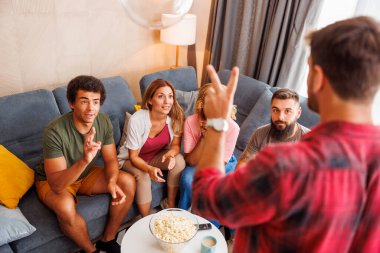 Bir grup arkadaş evde birlikte vakit geçirirken pandomim yaparken eğleniyorlar.