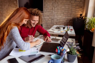 Şirket projeleri için planlama, beyin fırtınası ve fikir geliştirme konularında notlar alan iş adamları