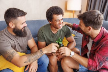 Bir grup erkek arkadaş evde vakit geçirip, kadeh kaldırarak ve bira içerek eğleniyorlar.