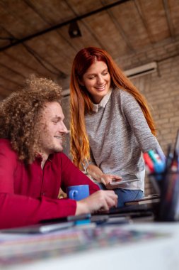 Modern çalışma alanında yeni bir proje üzerinde çalışan tasarımcılar; modern ofiste çalışan genç iş adamları