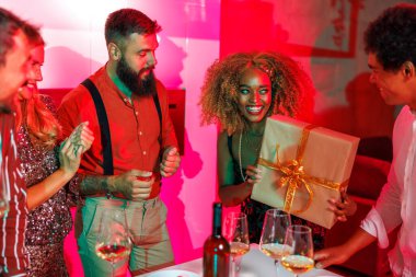 Bir grup neşeli genç arkadaş ev partisinde toplandı, arkadaşının doğum gününü kutlarken eğlendiler, ona bir hediyeyle sürpriz yaptılar.