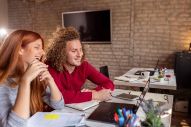Ortak çalışma alanında çalışan serbest bilişim uzmanları; modern ofiste çalışan genç iş adamları
