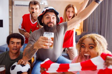 Neşeli arkadaşlar futbol fanatikleri eğleniyorlar, bira içiyorlar ve televizyonda dünya şampiyonluğu maçı izliyorlar.