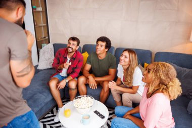 Bir grup arkadaş evde birlikte vakit geçirirken pandomim yaparken eğleniyorlar.