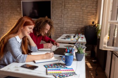 Öğrenciler online ders alırken plancılara notlar yazıyorlar; genç iş adamları sabah brifingi veriyorlar