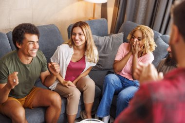 Bir grup arkadaş evde birlikte vakit geçirirken pandomim yaparken eğleniyorlar.