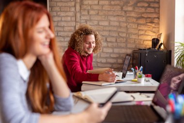 Modern bir ofiste çalışan gençler, çalışma alanında çalışan özgürlükçüler