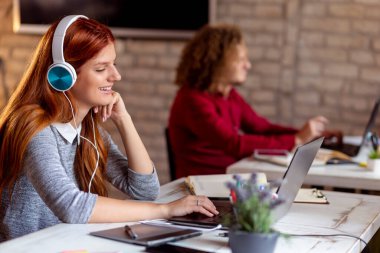 Web tasarımcısı modern bir ortak çalışma alanında yeni bir proje üzerinde çalışıyor; modern bir ofiste çalışan genç iş adamları