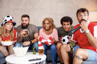 Futbol taraftarları, takımlarının golü kaçırıp maçı kaybetmesi üzerine evde TV 'de maç izleyerek eğleniyorlar.