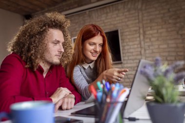 Modern çalışma alanında yeni bir proje üzerinde çalışan tasarımcılar; modern ofiste çalışan genç iş adamları