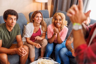 Bir grup arkadaş evde birlikte vakit geçirirken pandomim yaparken eğleniyorlar.