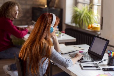 Web tasarımcısı modern bir ortak çalışma alanında yeni bir proje üzerinde çalışıyor; modern bir ofiste çalışan genç iş adamları