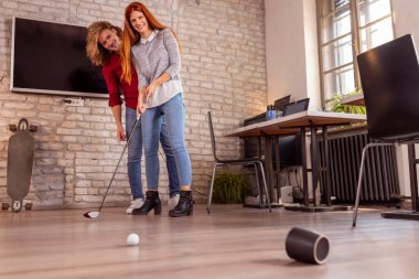 İş arkadaşları ofiste eğleniyor, mini golf oynuyor, serbest çalışanlar iş yerinde çalışıyor, ara veriyor ve mini golf oynuyor.