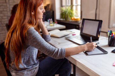 Modern bir ortak çalışma alanında yeni bir proje üzerinde çalışan kadın tasarımcı; çizim tahtası üzerinde çizim yapan web tasarımcısı. Eline odaklan.