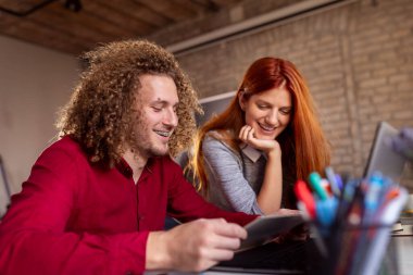 Modern çalışma alanında yeni bir proje üzerinde çalışan tasarımcılar; modern ofiste çalışan genç iş adamları