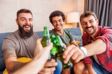 Bir grup erkek arkadaş evde vakit geçirip, kadeh kaldırarak ve bira içerek eğleniyorlar.