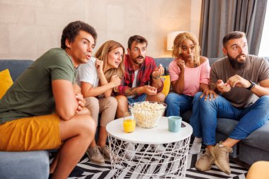 Bir grup arkadaş evde vakit geçirip, patlamış mısır yiyip, TV 'de korku filmi izleyerek eğleniyorlar.