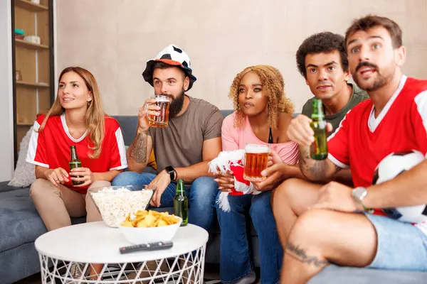 Bir grup arkadaş TV 'de futbol dünya şampiyonası maçı izliyor, tezahürat yapıyor, patlamış mısır yiyor ve bira içiyor.