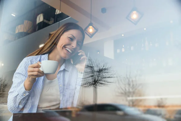 カフェで働く女性フリーランサーの肖像画 コーヒーを飲んだり 電話で会話をしたり — ストック写真