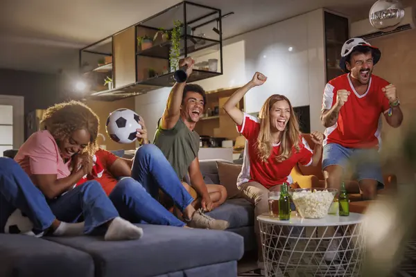 Ομάδα Νεαρών Οπαδών Ποδοσφαίρου Που Παρακολουθούν Παιχνίδι Στην Τηλεόραση Γιορτάζοντας — Φωτογραφία Αρχείου
