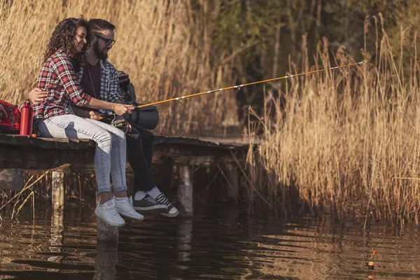 Birbirine aşık çiftler göl rıhtımlarında oturur, balık tutar ve doğada güneşli bir sonbahar gününün tadını çıkarırlar.